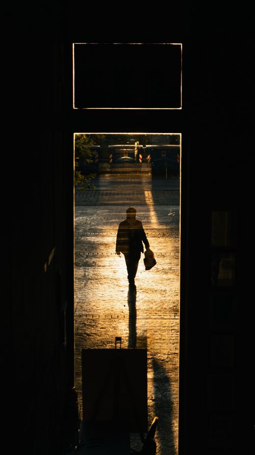 Free Dramatic silhouette of a person walking through a doorway at sunrise, Tirana, Albania. Stock Photo