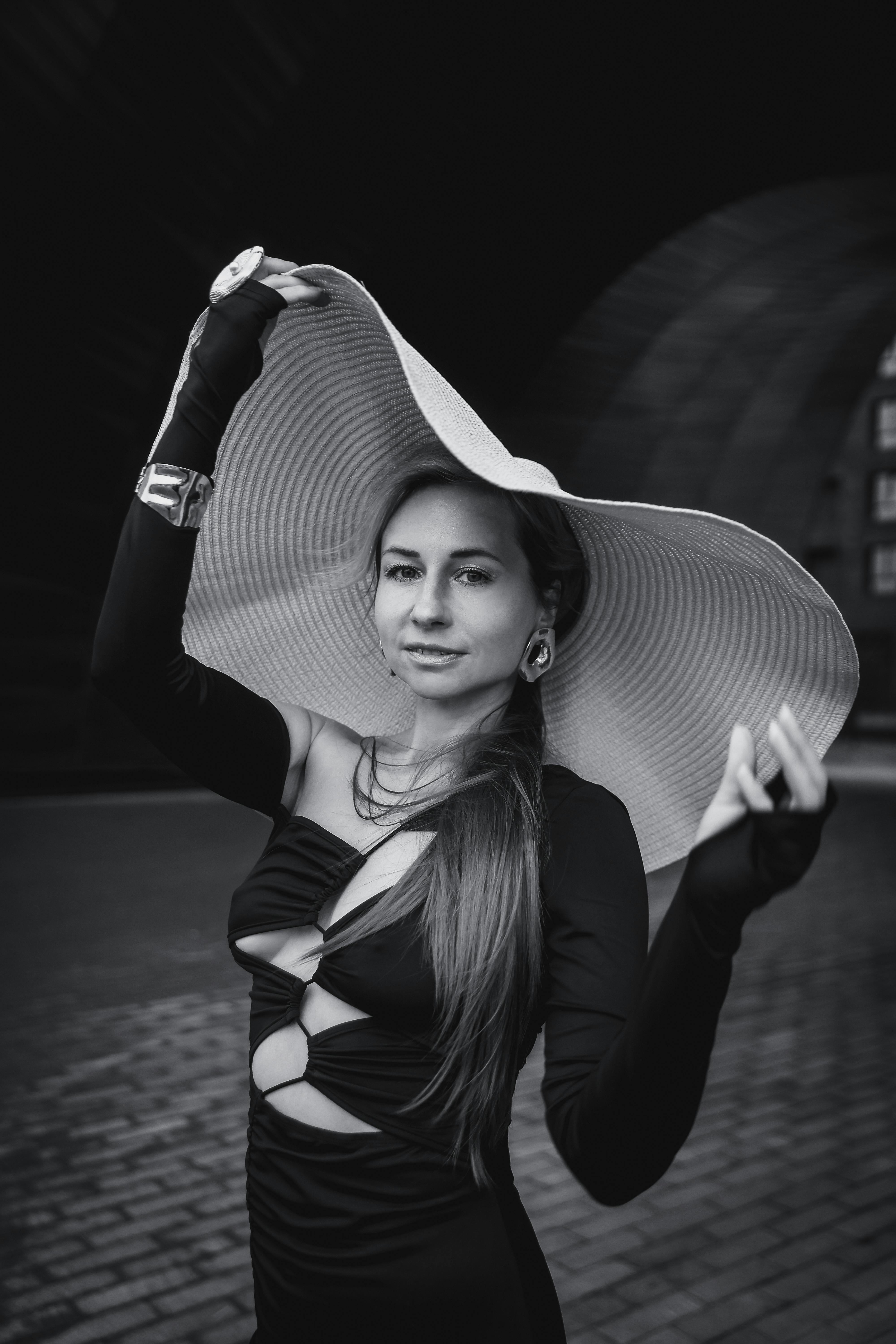 grátis Retrato elegante em preto e branco de uma mulher usando um chapéu de aba larga e uma roupa estilosa. Foto profissional