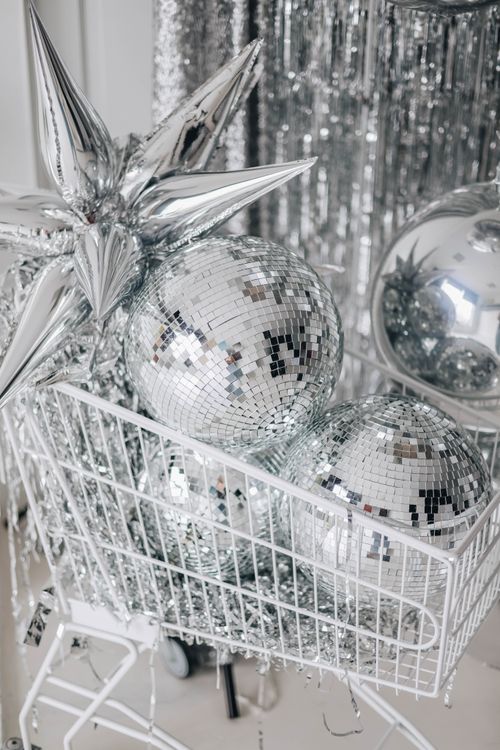 Free Silver disco balls and tinsel in shopping cart create a festive sparkle indoors. Stock Photo