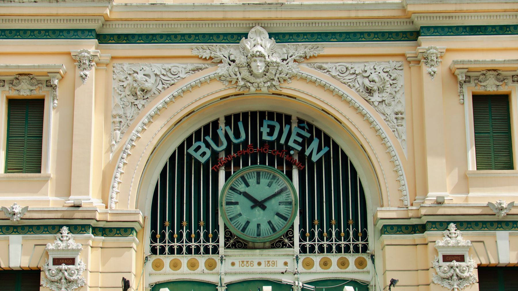 Ornate facade of the Ho Chi Minh City Post Office featuring decorative elements and a large clock.