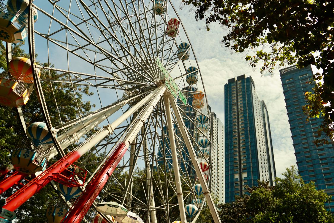 Ferris Wheel Against Urban Skyline on a Sunny Day · Free Stock Photo