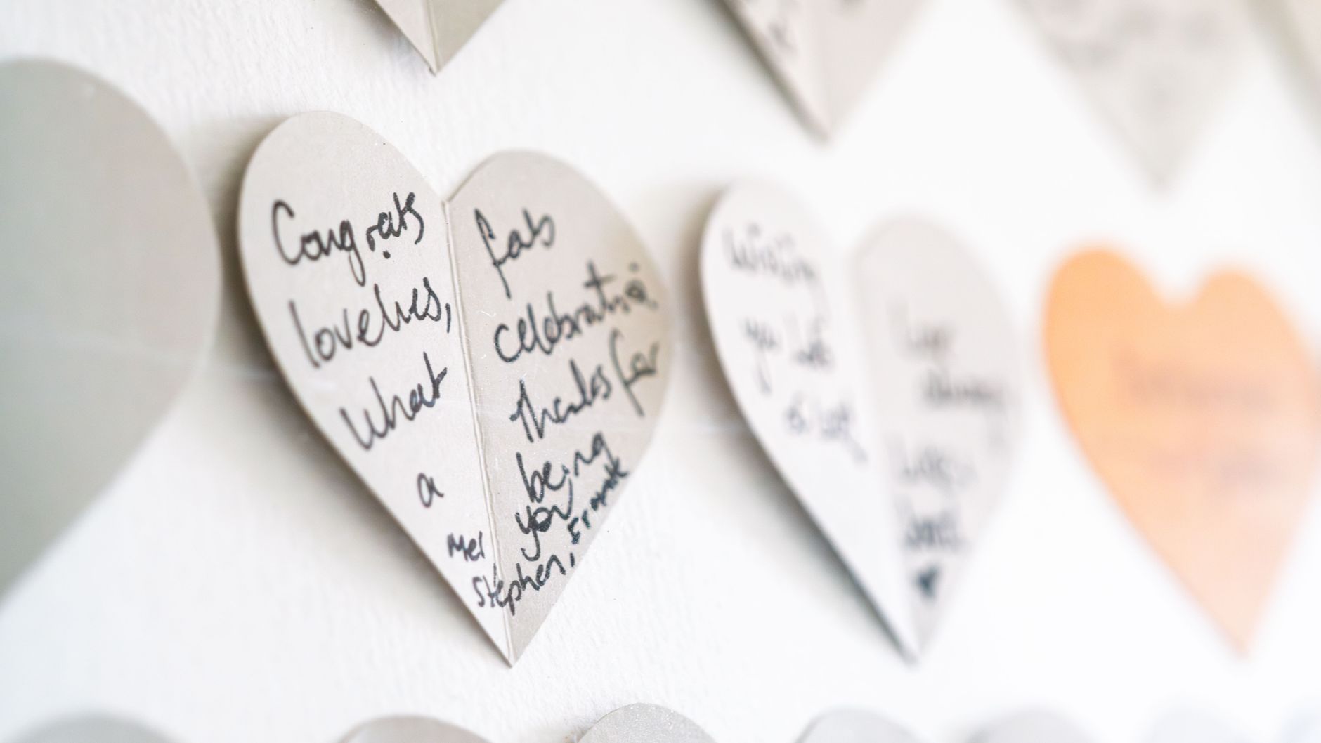 Heart-shaped cards displayed on a wall, showing creative card shapes