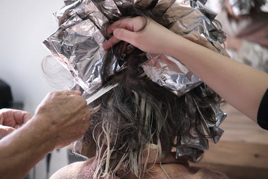 Close-up of a hairdresser applying color with foils in a salon, İzmir.
