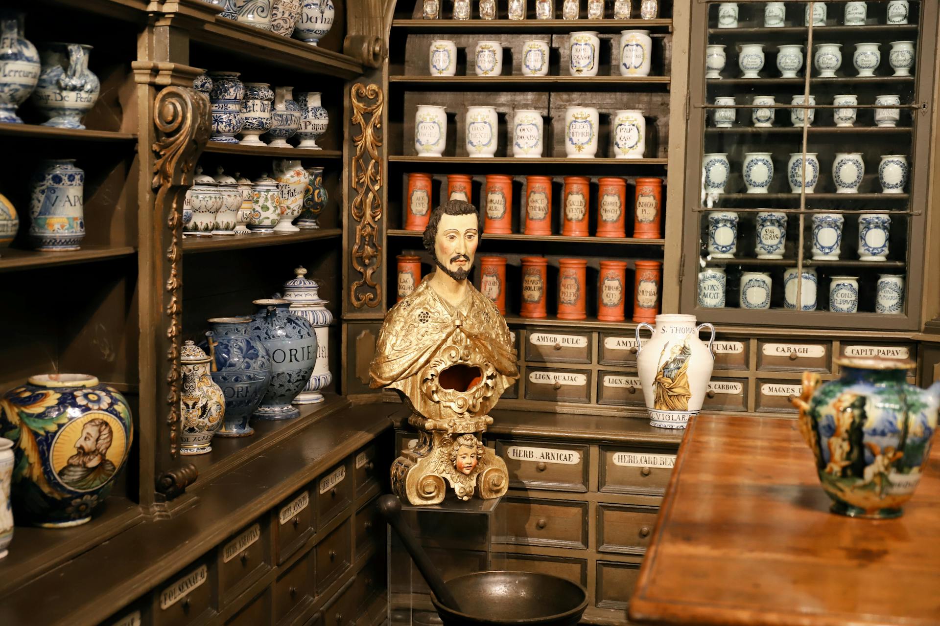 Intricate 18th-century pharmaceutical jars and bust at German Pharmacy Museum, Heidelberg.