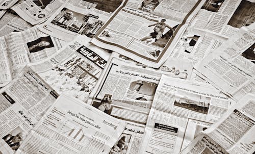 Free A collection of Arabic newspapers spread across a surface, showcasing diverse headlines and articles. Stock Photo