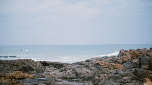 Free Scenic view of a rocky coastline with the ocean in the background under a cloudy sky. Stock Photo