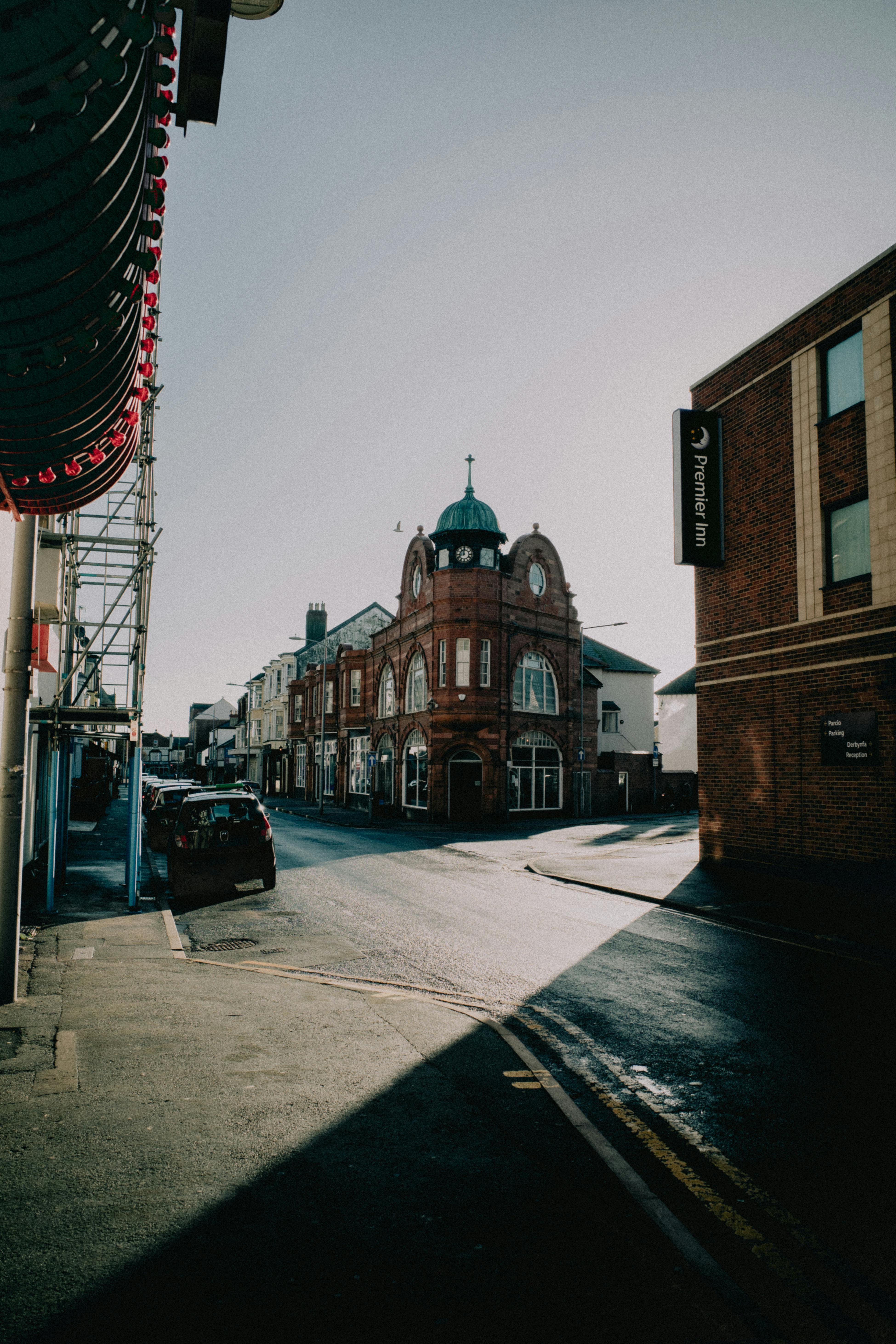 A quaint European street featuring distinguished brick architecture under bright daylight.