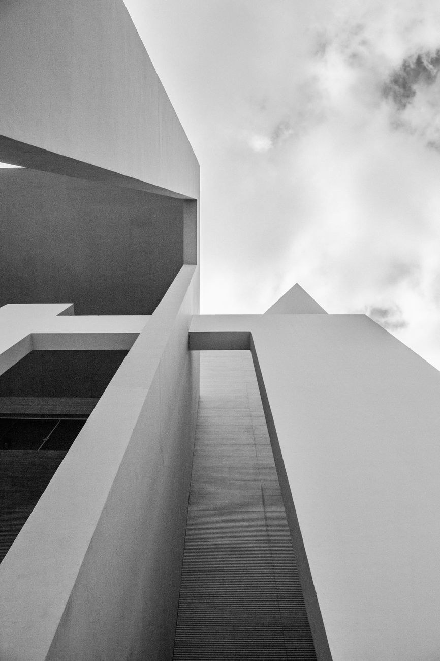 Striking modern architectural structure with geometric shapes and clear sky.
