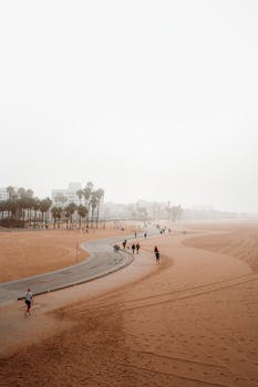 People walking along a cloudy Santa Monica beach path in Los Angeles, California.