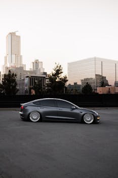 Modern car parked in downtown Los Angeles at dusk, showcasing cityscape and urban lifestyle.