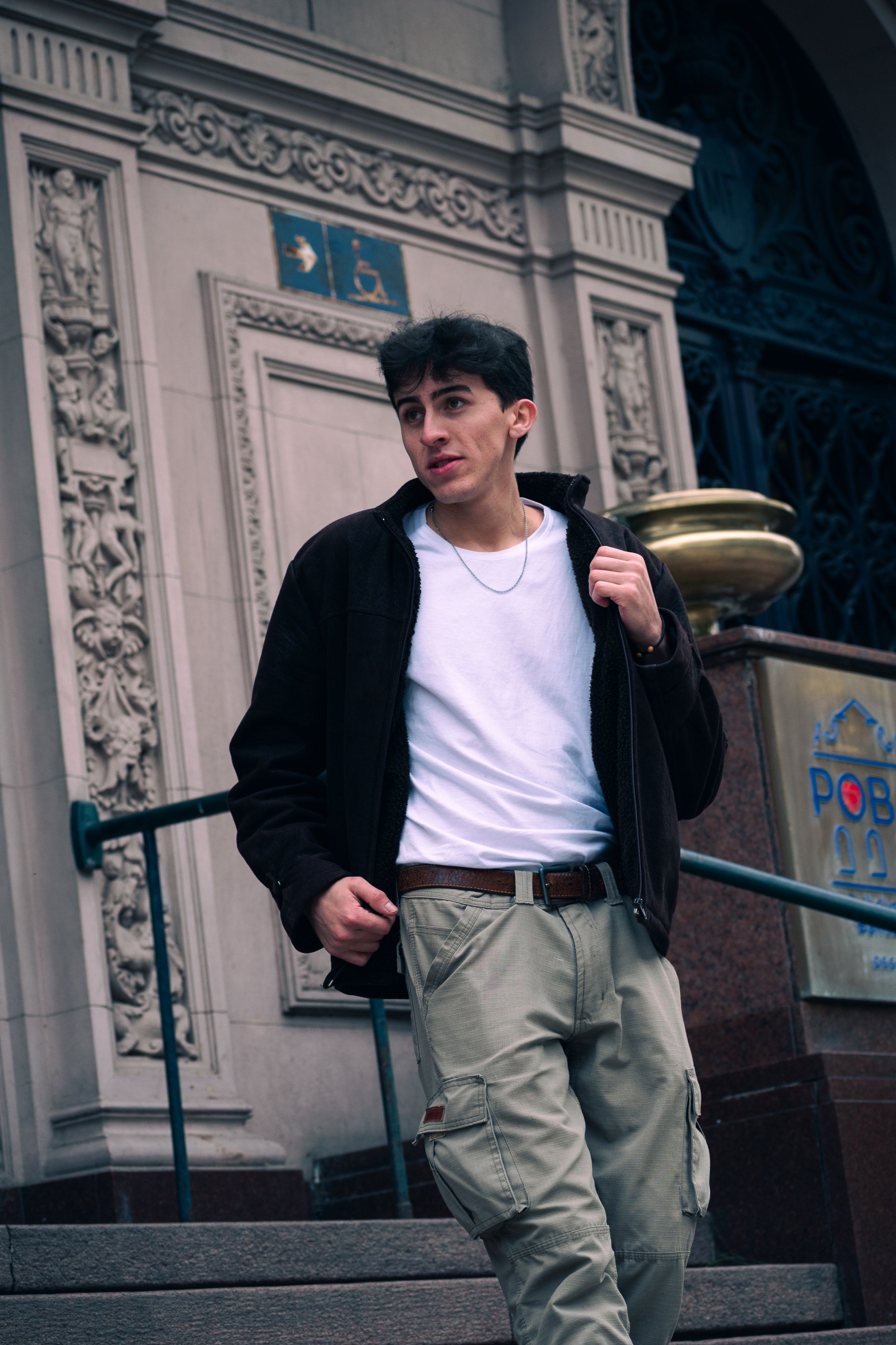 Portrait of a man in casual attire walking on the street steps in Buenos Aires.