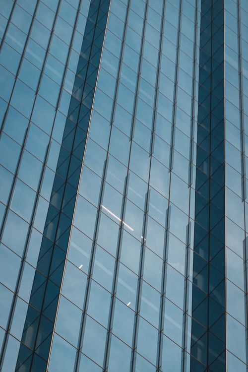 Free Reflective glass facade of modern skyscraper with symmetric geometric patterns. Stock Photo