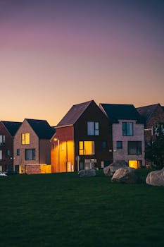 Modern suburban houses with stone accents under a twilight sky.