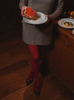 Woman holding a plate with caviar toast in an elegant indoor setting.