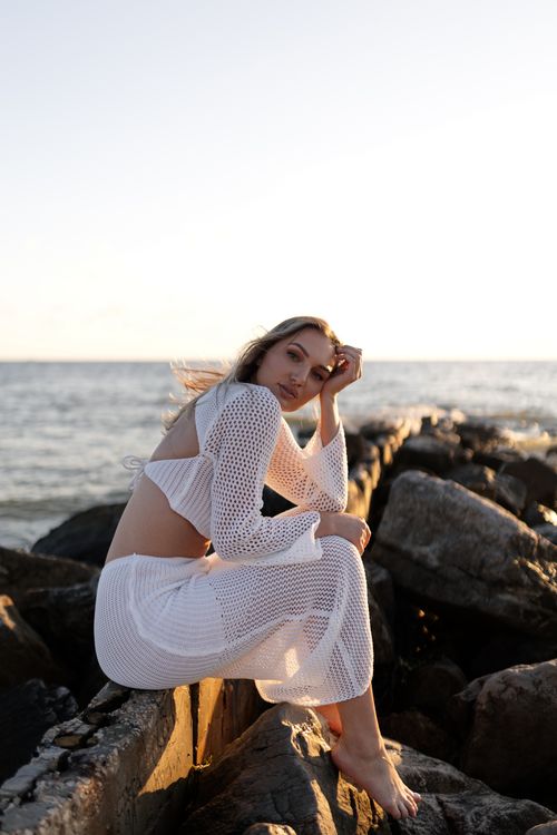 Woman in White Dress Posing by Sea at Sunset · Free Stock Photo