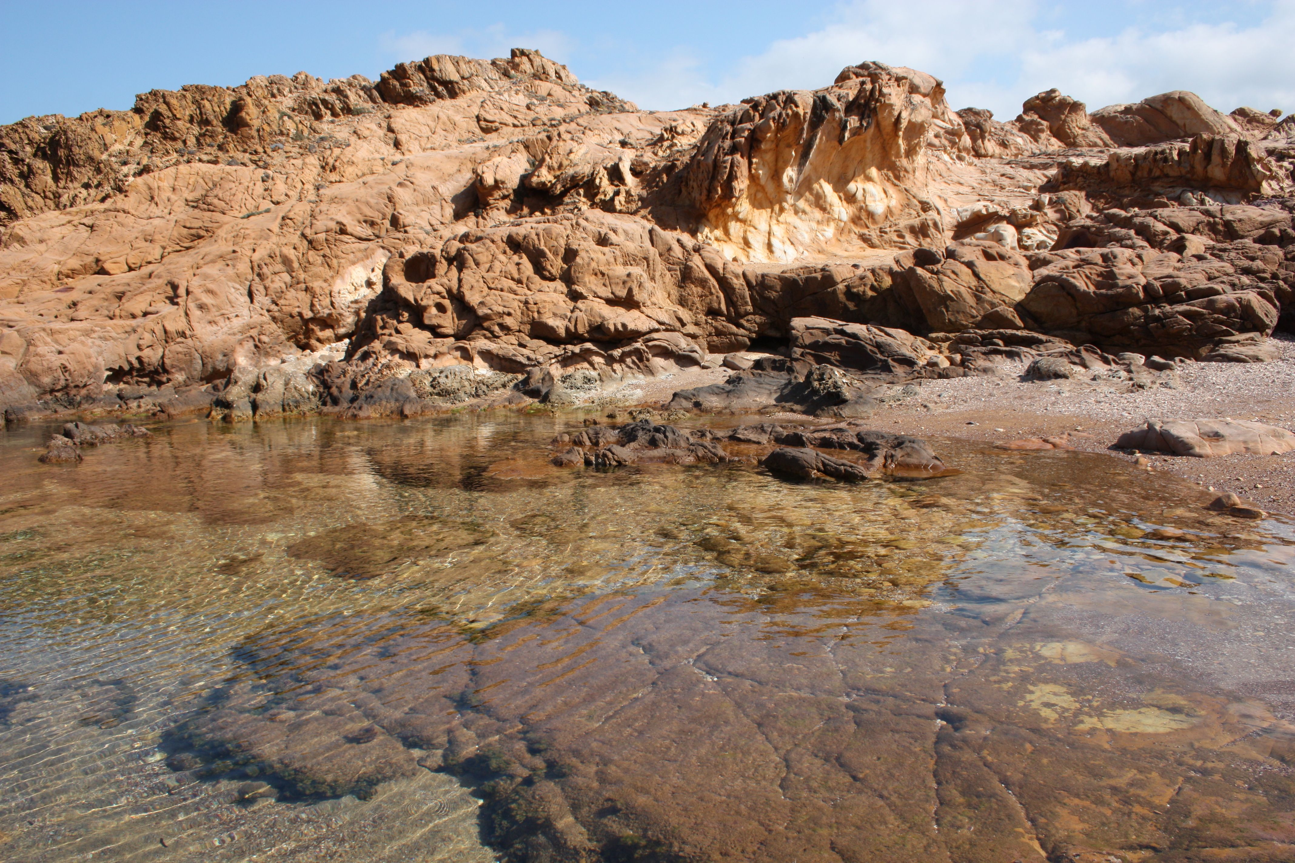 A tranquil rocky shoreline with clear tide pools reflecting the clear skies.. pexels, tranquil, rocky