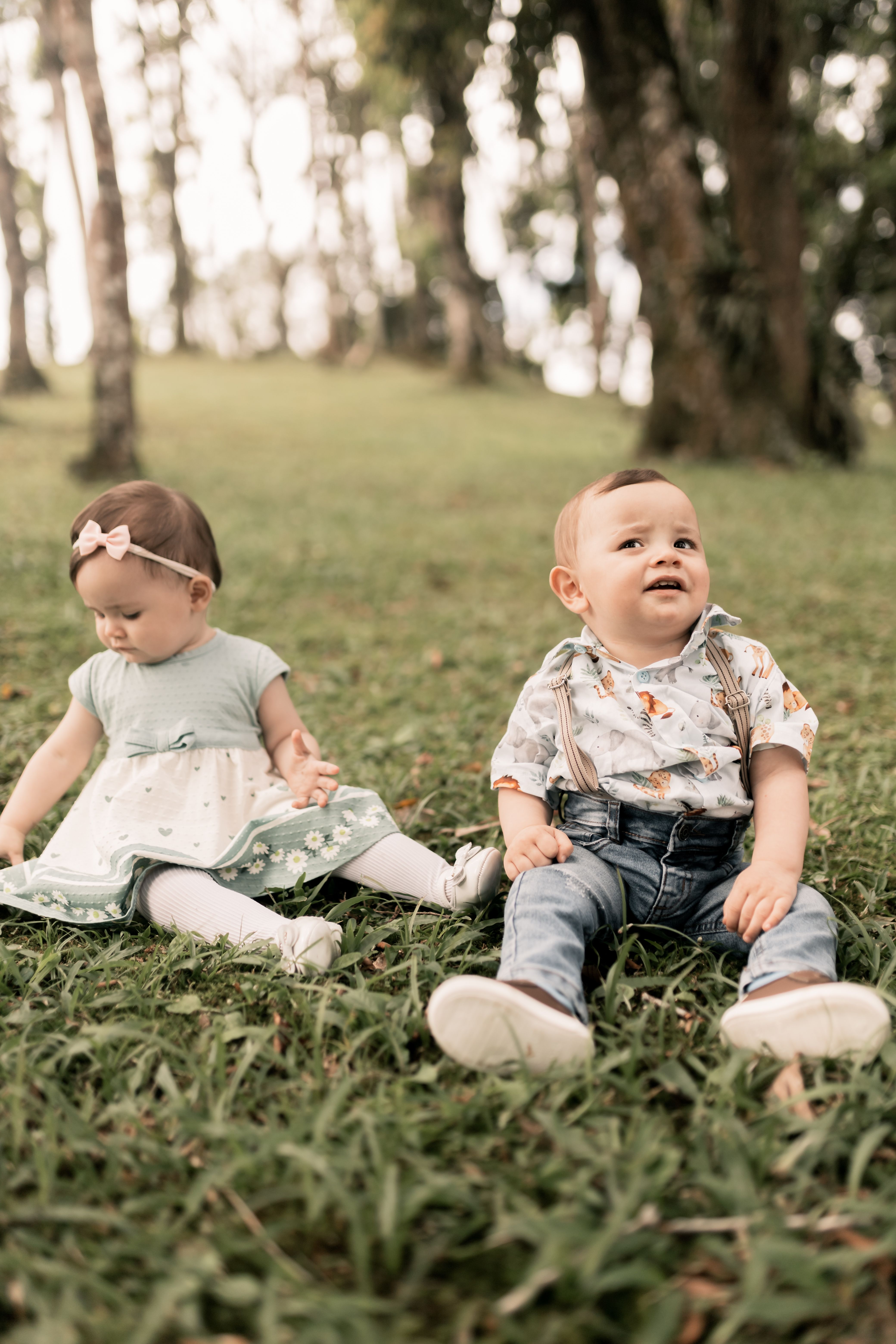 Two babies enjoying a serene outdoor setting, surrounded by nature.