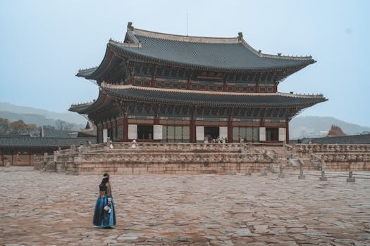 Woman in traditional hanbok attire walking past Seoul's iconic Gyeongbokgung Palace.