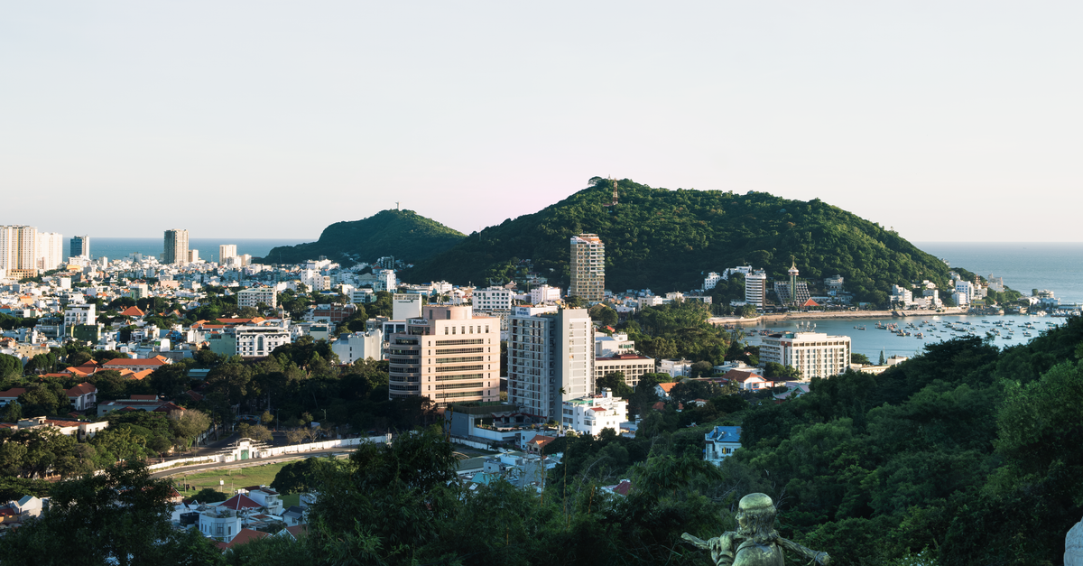 A picturesque aerial view of Vũng Tàu City with lush hills and coastal skyline.