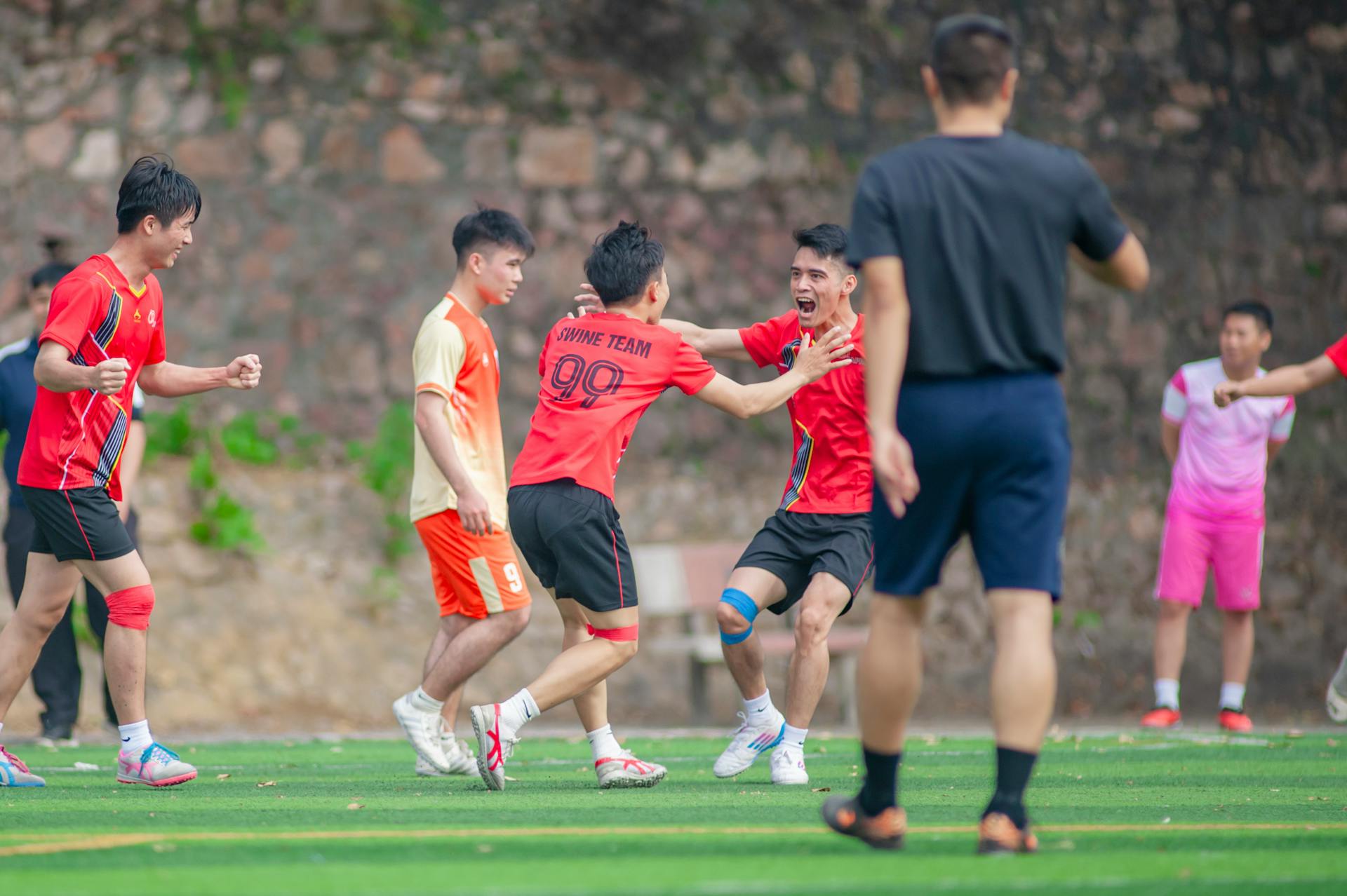 A joyous moment of soccer players celebrating a victory on the field in Hanoi, Vietnam.