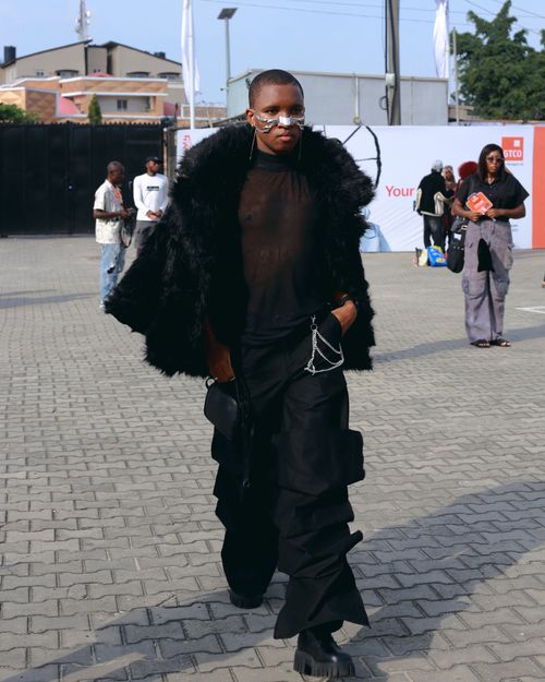 Free Stylish individual in bold black outfit walking in urban outdoor setting, exuding confidence and style. Stock Photo
