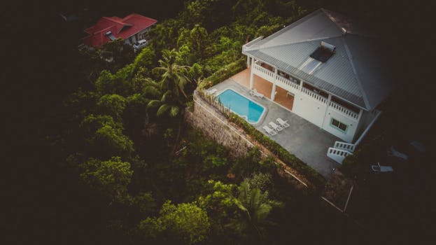 Dive into tranquility with this aerial shot of a secluded villa in Anse Royale, Seychelles, featuring lush greenery and a private pool.