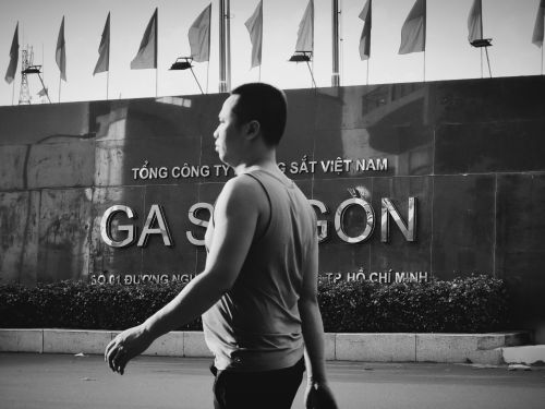Free Black and white street scene with a man walking past Saigon Railway Station in Ho Chi Minh City. Stock Photo