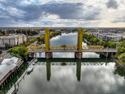 Free Aerial view of the iconic Tower Bridge spanning the Sacramento River under dramatic skies. Stock Photo