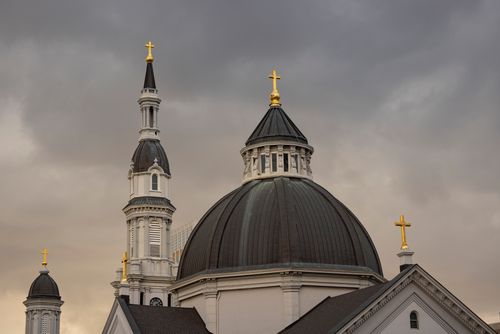 Free A church with striking architecture stands against a dramatic cloudy sky. Stock Photo