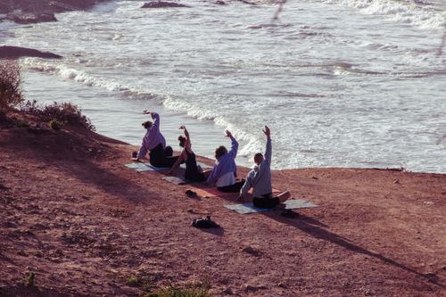 Free A peaceful outdoor yoga session by the ocean in Morocco, with a warm and earthy tone. Stock Photo