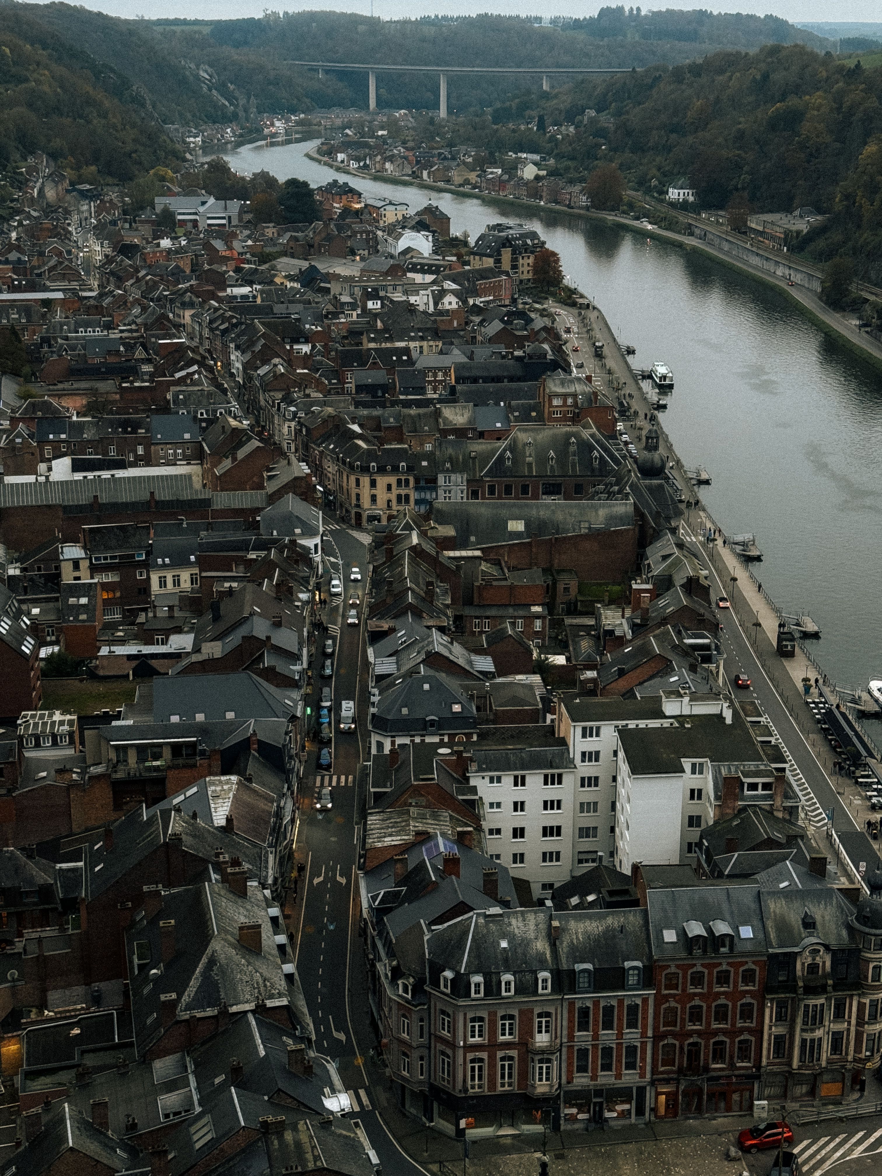 Stunning aerial view of Dinant, Belgium, showcasing the city's historic rooftops and the Meuse River.
