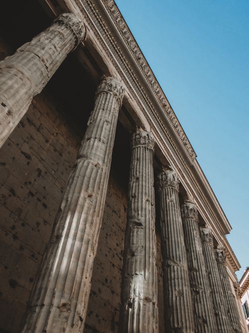 Free Stunning upward view of ancient Roman columns against a clear sky in Rome, Italy. Stock Photo