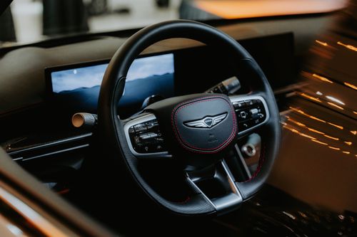 Free Close-up of a luxury car steering wheel with elegant design and advanced controls in a modern vehicle interior. Stock Photo
