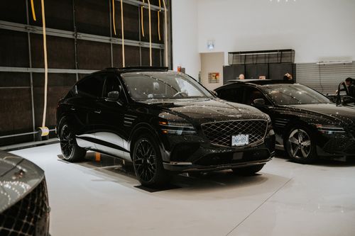 Free Luxury black SUVs displayed in an indoor car showroom with elegant lighting. Stock Photo