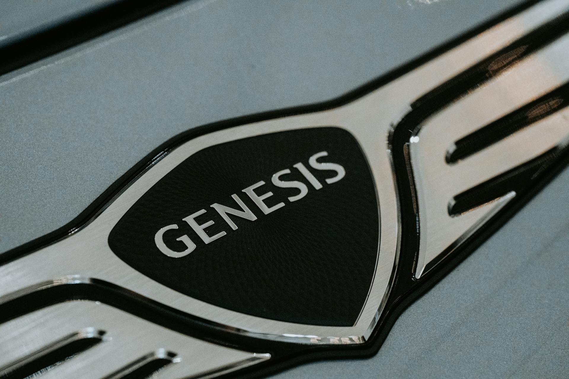 Detailed close-up of the Genesis car logo emblem for automotive branding.