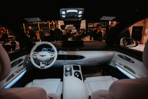 Free Elegant car interior view with people at a sophisticated event in the background. Stock Photo