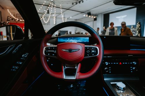 Free Elegant car interior featuring a red steering wheel and modern dashboard controls. Stock Photo