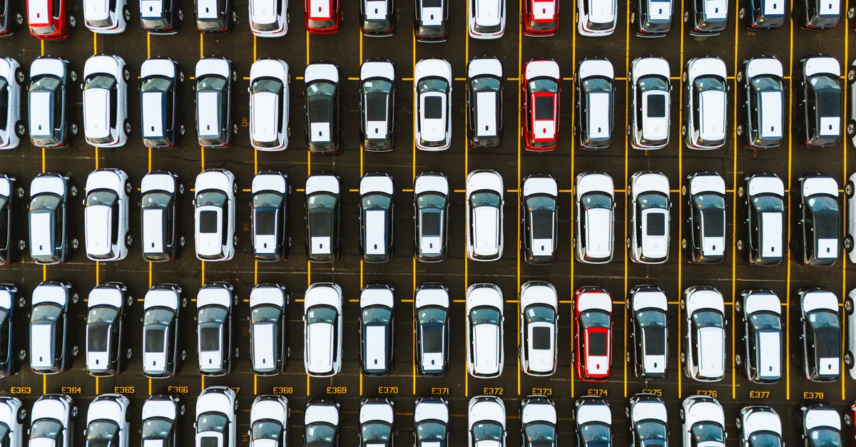 An aerial shot capturing a symmetrical layout of parked cars in a parking lot.