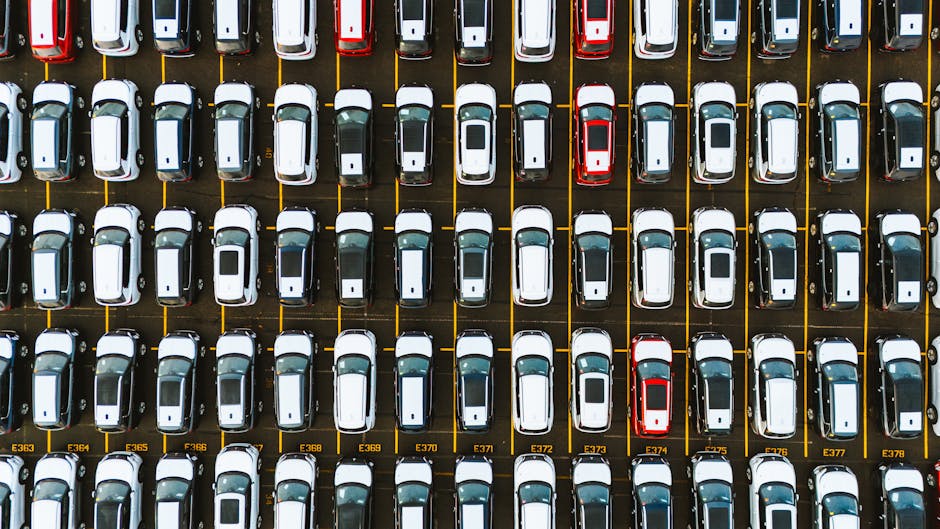 An aerial shot capturing a symmetrical layout of parked cars in a parking lot.