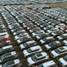 Aerial view of hundreds of vehicles lined up in an expansive commercial staging lot.