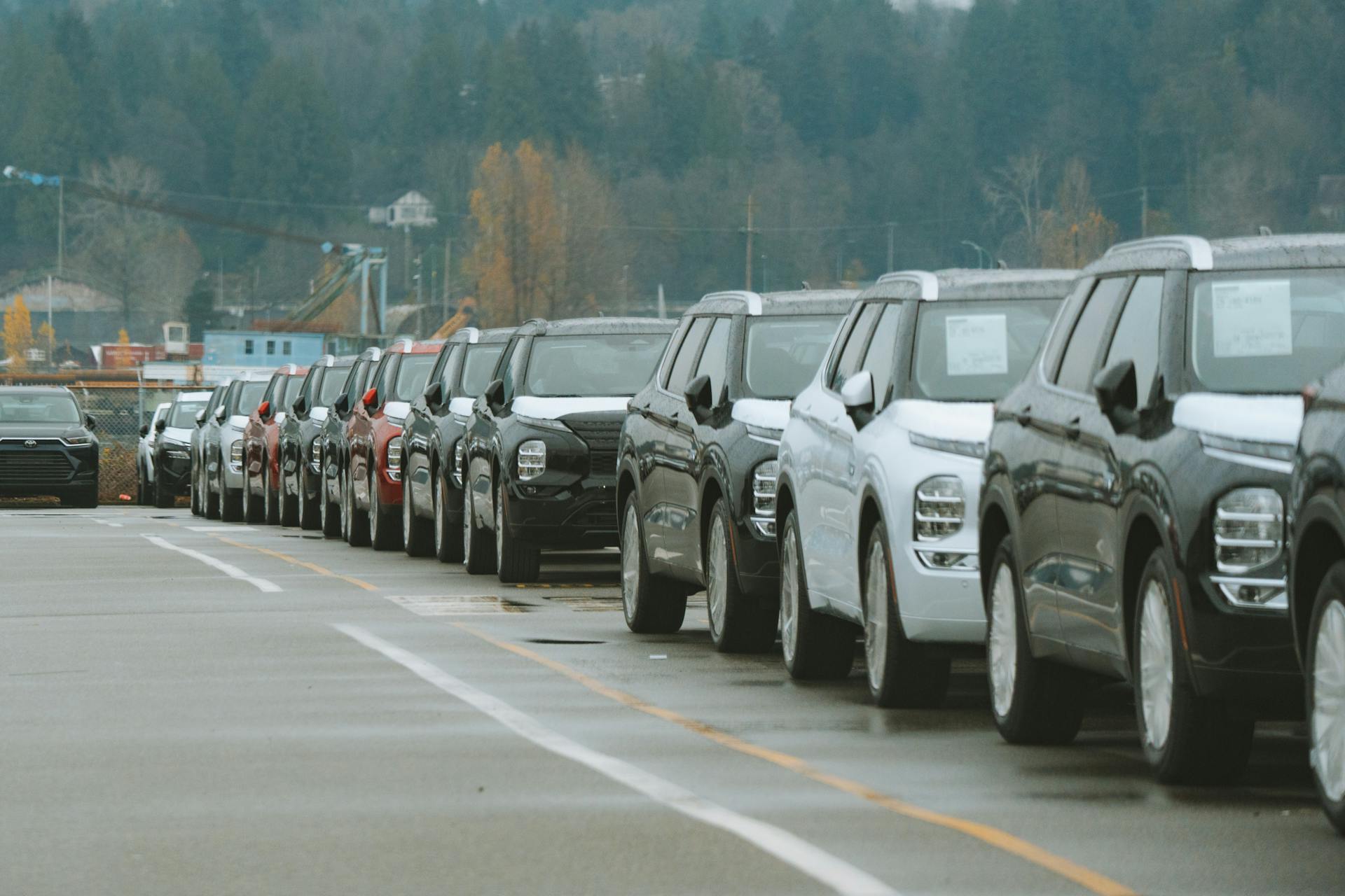 A line of new SUVs parked in an outdoor dealership lot, ready for sale.