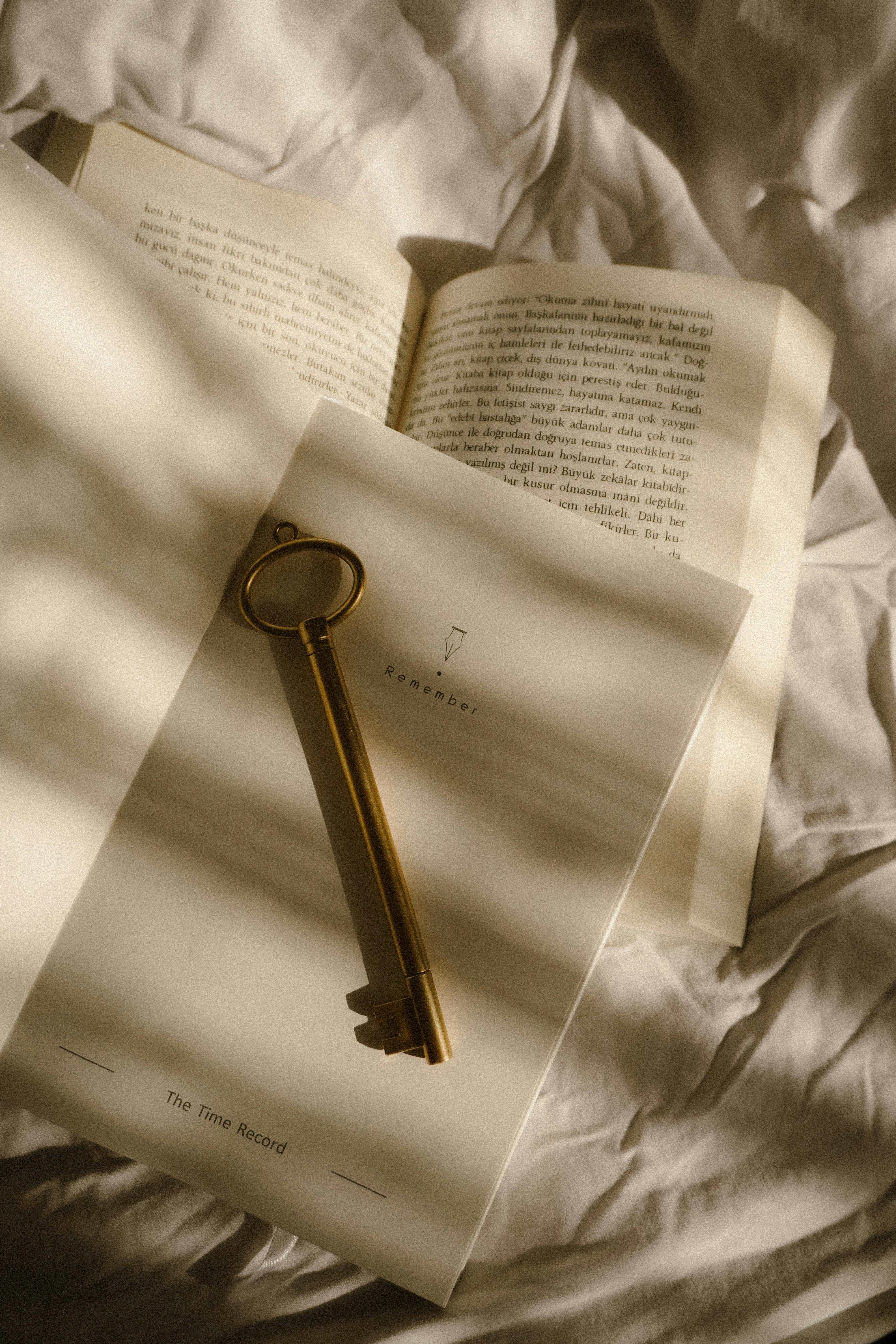 Aesthetic shot of a vintage key on an open notebook, casting soft shadows.