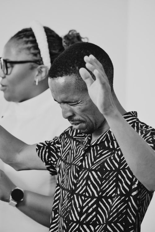 Free Black and white photo capturing two adults in a moment of joyful worship. Stock Photo