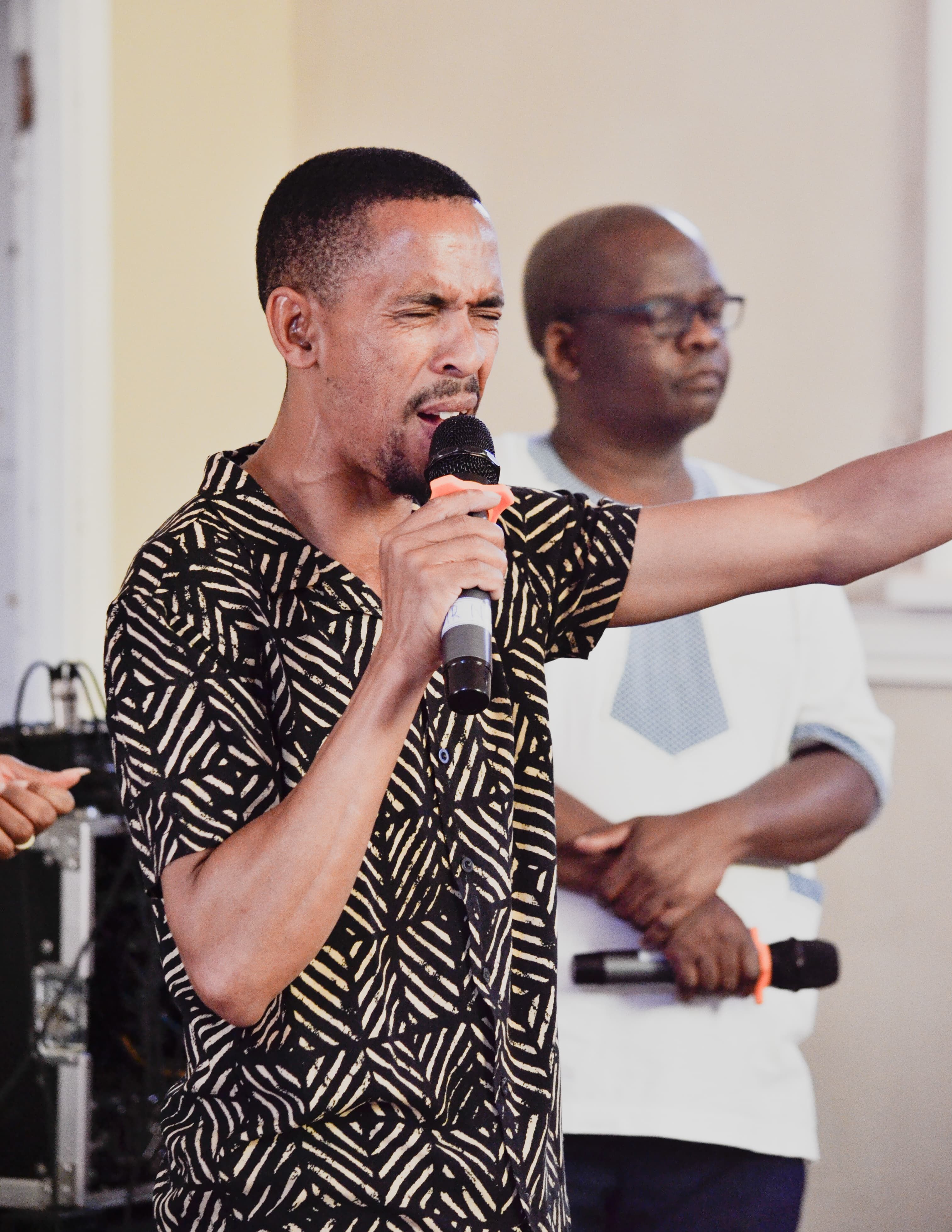 Male singer passionately performing with microphone during indoor event.