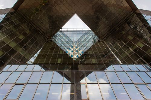 Free Symmetrical view of a modern building facade, showcasing glass reflections. Stock Photo