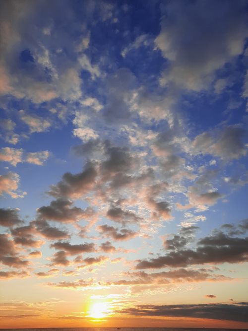 Free A stunning sunrise with vivid colors and dramatic clouds over the horizon. Stock Photo