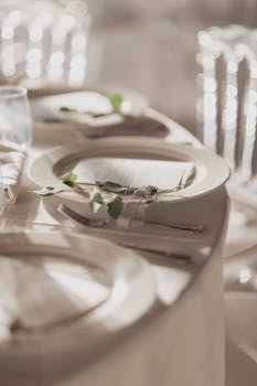 Elegant wedding table setup with eucalyptus, soft lighting in Italia.