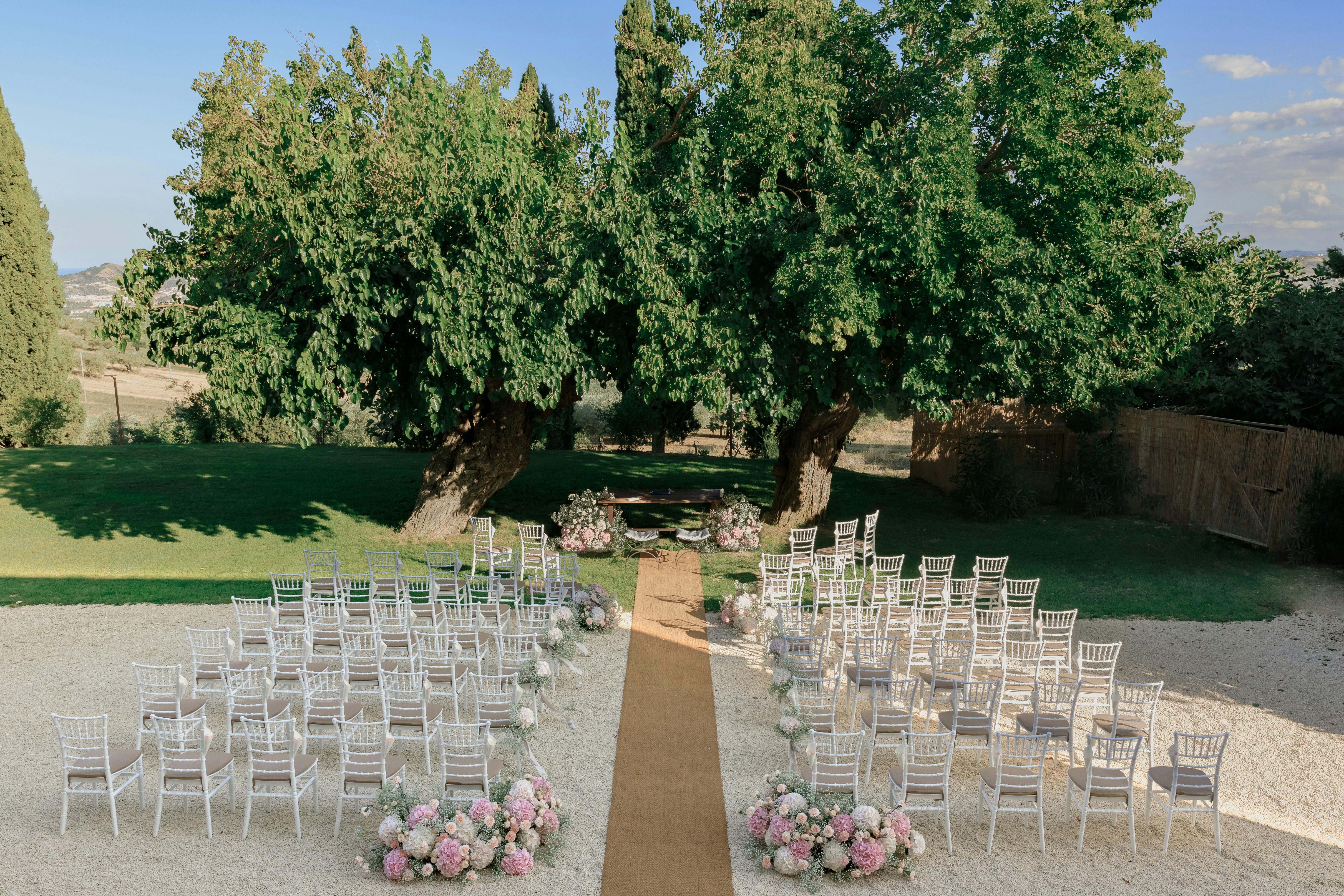 Beautiful outdoor wedding setup with floral arrangements in an Italian garden.