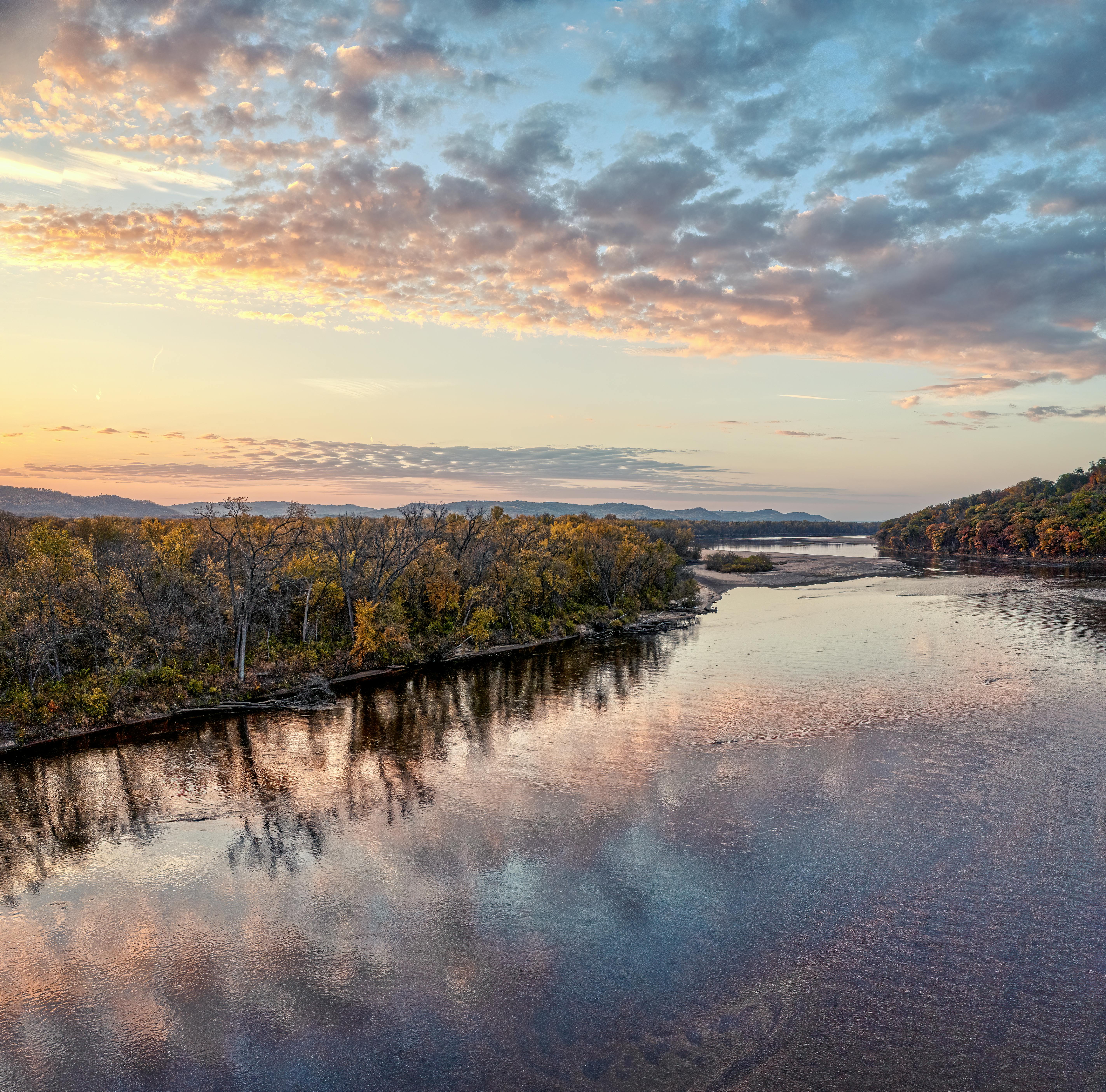 Beautiful autumn river scene with reflections under a colorful sunset sky.