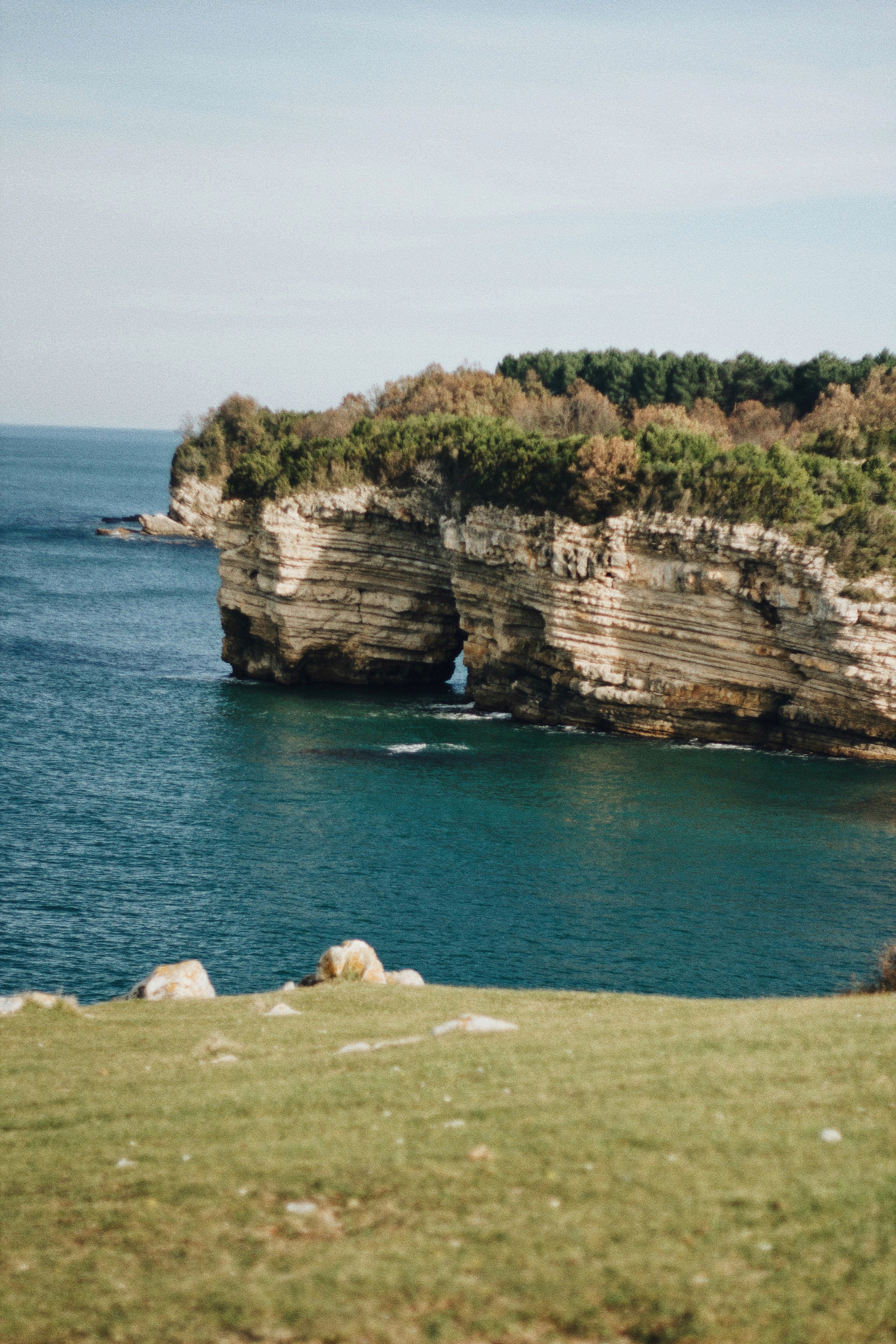 Beautiful coastal cliffs with lush greenery by the turquoise sea, perfect for travel inspiration.